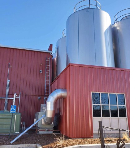 Gutters on a commercial metal building with a red roof