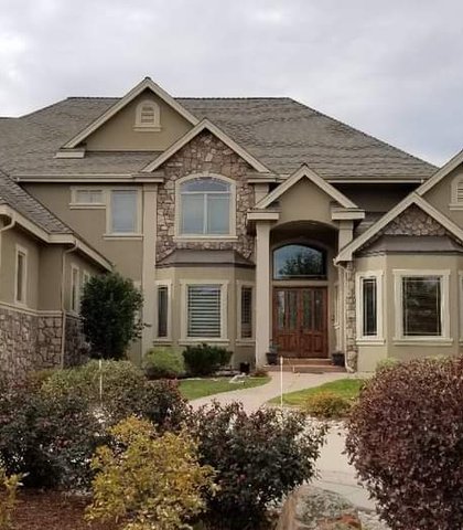 Seamless gutters on a large stone and stucco two-story home