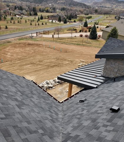 Gutter install on a metal-roof home with a Front Range valley view