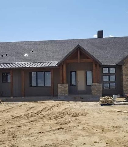 New seamless gutters on a stone-accent ranch under construction