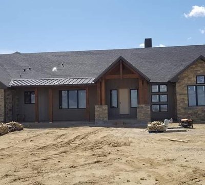 New-construction stone and stucco Northern Colorado home with freshly installed seamless gutters