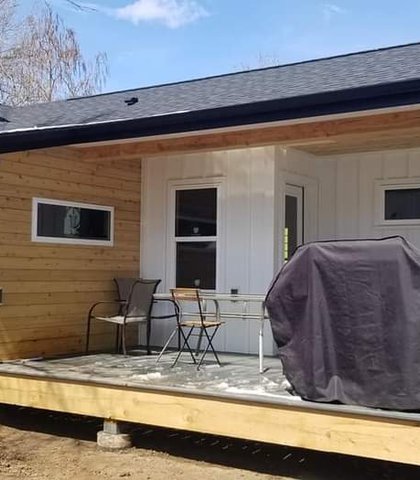 Gutters and downspouts on a tan home with a covered porch